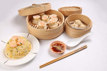 Prawn shrimp shaomai Xiao long bao dim sum dumpling chicken prawn fish seafood vegetable in bamboo steamer sauce chopsticks on white background