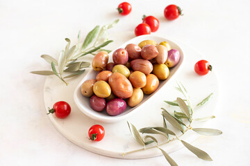 Pink and Purple kalamata olives. Tasty organic colored kalamata olives in the plate. Olive on marble floor