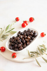 Black olive. Tasty organic black olives in the plate. Olive on marble floor