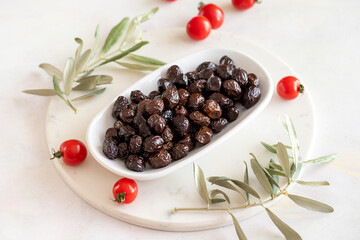 Black olive. Tasty organic black olives in the plate. Olive on marble floor