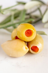 Close-up of green olives with pepper filling. Organic green olives on a marble floor