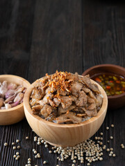 Thai food, Rice topped with pork and garlice in wooden bowl on brown wooden table. Favorite food in Thailand.