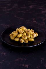 Grilled green olives on a dark background. Tasty Green grilled olives in the bowl