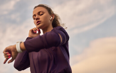 Female runner checking fitness tracker during training