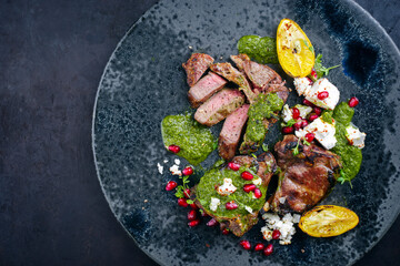 Modern style traditional barbecue T-Bone lamb steaks with Greek feta cheese, chimichurri sauce and...