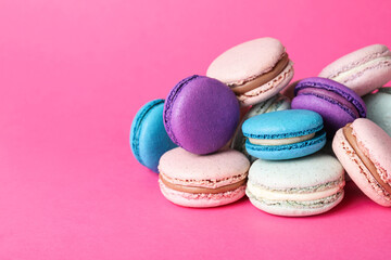 Fototapeta na wymiar Pile of delicious colorful macarons on pink background. Space for text