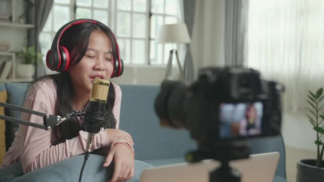 Asian Girl Vlogger Singing While Streaming For Her Youtube Channel. The Child Is Broadcasting Live On The Internet.
