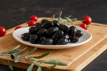Kalamata olives. Tasty black kalamata olives in the plate.