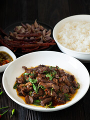 Thai food, Stir fried meat and basil in white plate on brown wooden table. Favorite food in Thailand.