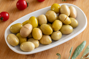 Yellow olive. Tasty organic yellow olives in the plate. Olives on wooden background