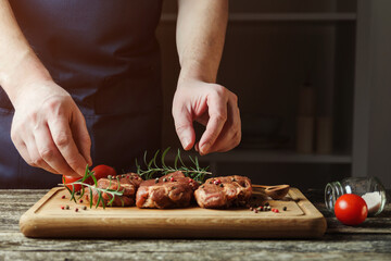 Chef hands cooking meat steak. Chef adding salt and pepper on raw meat.
