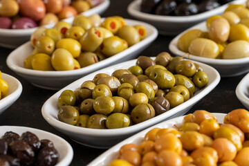 Assortment of olives on the plate in bulk. Organic black olives, Olive varieties