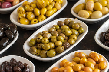 Assortment of olives on the plate in bulk. Organic black olives, Olive varieties
