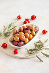 Pink and Purple kalamata olives. Tasty organic colored kalamata olives in the plate. Olive on marble floor