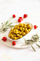 Grilled green olives. Tasty organic green olives in the plate. Olive on marble floor