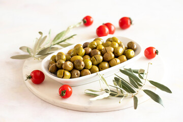 Scratched green olives. Tasty organic green olives in the plate. Olive on marble floor