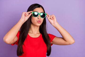 Photo of pretty flirty young lady wear red outfit arms dark eyewear sending kiss isolated violet color background