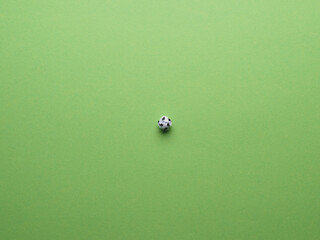 Soccer field, view from above, crumpled paper ball as a soccer ball on a green paer background as...