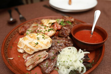 Assorted grilled meat with sauce on plate