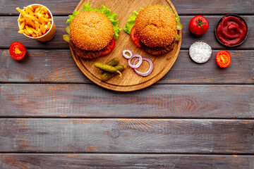 Bbq hamburgers with french fries on servise board. Top view