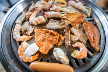 Close-up on top of the BBQ grilling meal with various kind of meat such as pork, beef, bacon and shrimp. Food photo.