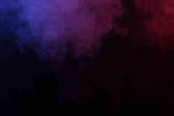 Artificial magic smoke in red-blue light on black background
