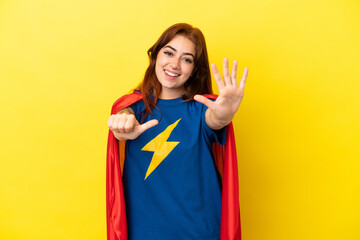 Super Hero redhead woman isolated on yellow background counting six with fingers