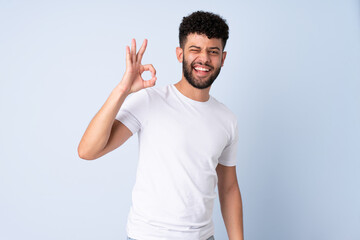 Fototapeta premium Young Moroccan man isolated on blue background showing ok sign with fingers