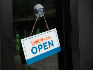"Come in we're open" in cafe.We're Open hang on door or window of business shop.