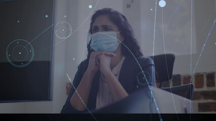 Animation of network of connections over worried businesswoman wearing face mask in office - Powered by Adobe