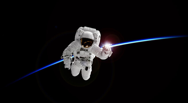 Astronaut in outer space  earth and horizon has rising sun. Elements of this image furnished by NASA