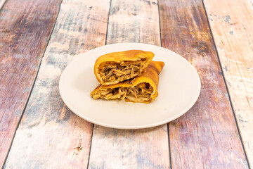 Corn patty cut in half to show the filling of shredded meat inside