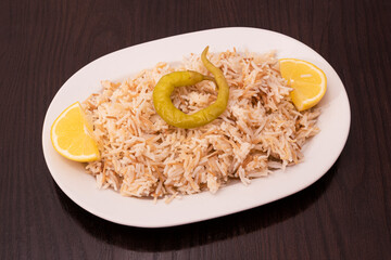 White tray of basmati rice with lemon and pickled chili pepper