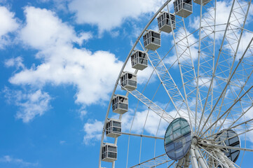 Ferris wheel in a sunny day with white clouds