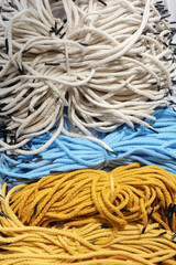 Background of many colorful synthetic handle cord for paper packets. Part of the packaging bags.