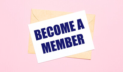 On a light pink background - a craft envelope. It has a white sheet of paper that says BECOME A MEMBER