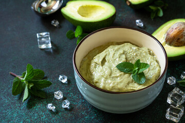 Ice cream, sweet snack or dessert. Homemade avocado fruit ice cream, summer tropical fruit sorbet on a stone table.