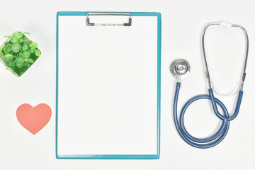 Blank paper sheet on clipboard with stethoscope and heart shape on the side. 