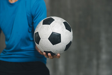 boy wearing blue shirt holding a classic football