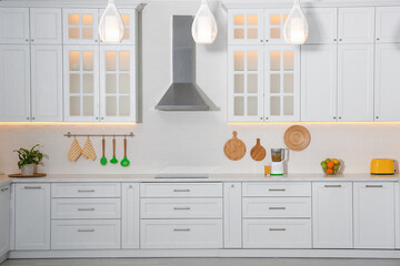 Light kitchen interior with stylish furniture and modern equipment