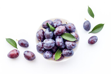 Food layout with plums in bowl with leaves. Top view