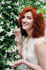 portrait of a young red hair woman on white flowers background