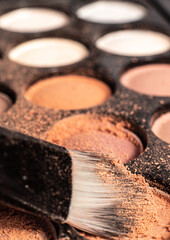 Fototapeta premium eye shadow is close. A makeup brush with eye shadow on it scatters the grains. macro palettes with shadows