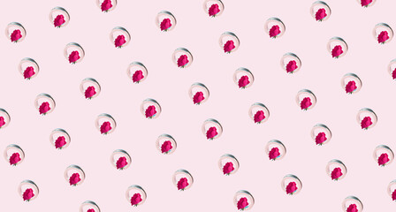 Red roses creative pattern in a metal ring. Minimal concept on pastel pink background.