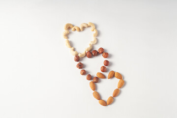 from almonds, hazelnuts, cashews are laid out three hearts. View from above