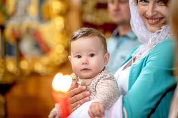 The baptism of a baby in the temple, the mother holds the baby in her arms, a holy place, a church,...
