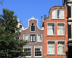 Fototapeta na wymiar Amsterdam Canal House Facades Against a Blue Sky