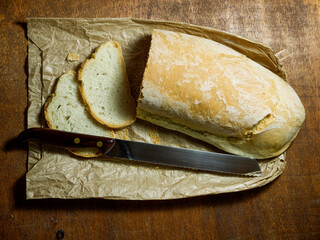 loaf of bread, with some freshly cut slices and the knife nearby