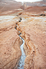 Hverir geothermal area in North of Iceland, Boiling volcano mud pots and cracked red ground