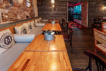 Interior of the restaurant with sofas at the wall and chairs.